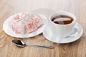 Cup of tea, plate with rakhat-lukum and teaspoon