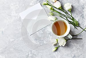 Cup of Tea and Prairie Gentian Flowers on gray stone background