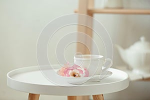 Cup of tea, saucer and flowers on table