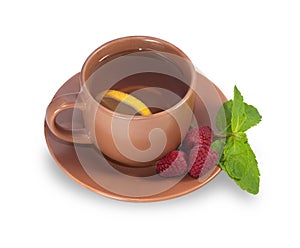 Cup of tea on a saucer with lemon, raspberry and mint leaves iso