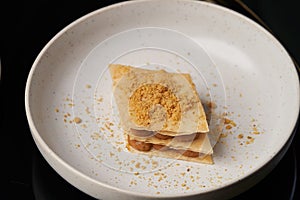 Cup of tea and slice of cheese cake on white plate on table
