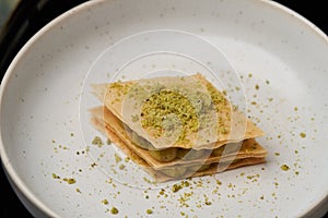 Cup of tea and slice of cheese cake on white plate on table