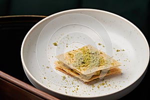 Cup of tea and slice of cheesecake on white plate on table