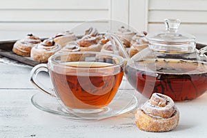 Cup of tea and small apple roses shaped pies. Sweet apple dessert pie. Homemade apple rose pastry. Breakfast tea with sweet apple