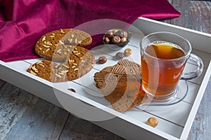 A cup of tea and spiced bisquit on a tray