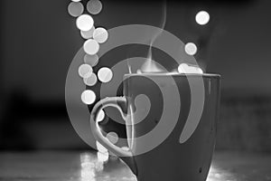 Cup of tea with steam and soft Bokeh. Black and white photography.