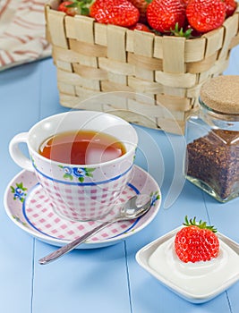 A cup of tea with a strawberry-yogurt dessert