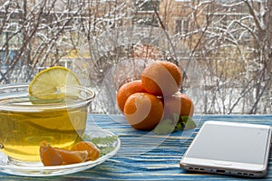 A cup of tea and sweets, on a blue wooden background