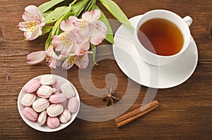 Cup of tea with sweets and flowers