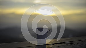 Cup with tea on table over mountains landscape