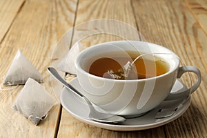 Cup with tea and tea bag pyramid. close-up. on a wooden table. to make tea