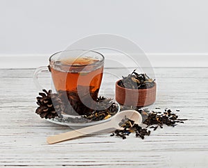 Cup of tea with tea leaves scattered.