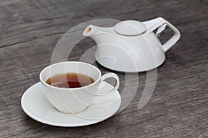 Cup of tea and tea's jar on old wooden