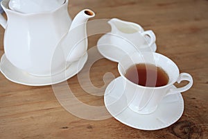 Cup of tea and tea's jar on old wooden