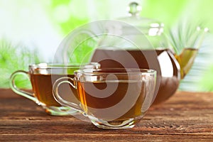 Cup of tea and teapot on nature background