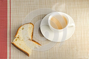 Cup of tea with two bread for breakfast on tablecloth