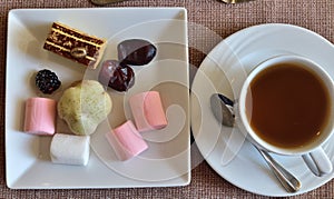 A cup of tea and various sweets
