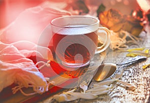 Cup of tea with white flowers petals on wooden table, vintage effect, retro toned, atmospheric mood. Morning soft light. Rustic