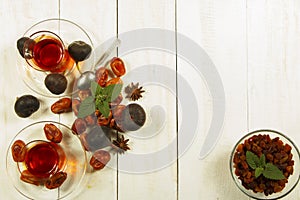 A cup of tea on a white table.Traditional Arabic, Turkish Ramadan tea with dry dates and raisins on a wooden white table. Turkish