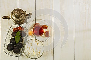 A cup of tea on a white table.Traditional Arabic, Turkish Ramadan tea with dry dates and raisins on a wooden white table. Turkish