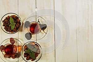 A cup of tea on a white table.Traditional Arabic, Turkish Ramadan tea with dry dates and raisins on a wooden white table. Turkish