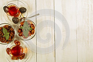 A cup of tea on a white table.Traditional Arabic, Turkish Ramadan tea with dry dates and raisins on a wooden white table. Turkish