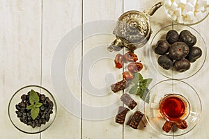 A cup of tea on a white table.Traditional Arabic, Turkish Ramadan tea with dry dates and raisins on a wooden white table. Turkish