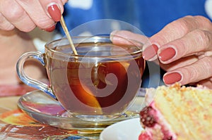 In a Cup of tea, a woman kneads sugar.