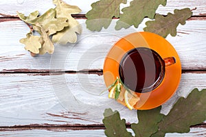 Cup of tea on a wooden background with autumn leaves. Top view
