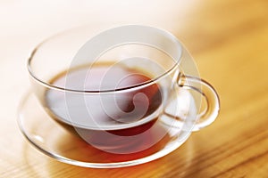 Cup of tea on a wooden table in the sunlight. Close-up