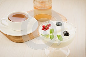 cup tea, yogurt with berries and honey jar/cup tea, yogurt with berries and honey jar on wooden background. selective focus