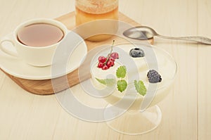 cup tea, yogurt with berries and honey jar on wooden background/cup tea, yogurt with berries and honey jar on wooden background.