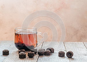 A cup of traditional Chinese puer tea with aged puerh tea bricks