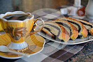 Cup of Turkish coffee and slices of poppy seeds strudel rolls