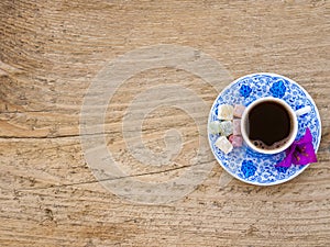 A cup of Turkish coffee with sweets and spices on a wooden surface