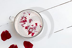 Cup of warm ayurvedic moon milk for a better nights sleep with rose petals