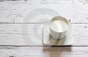 Cup of warm milk on a wooden background. White Cup with milk.