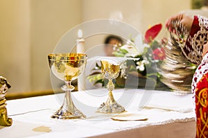 Cup with wine and ciborium with host on the altar of the holy mass