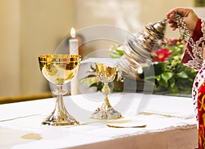 Cup with wine and ciborium with host on the altar of the holy mass