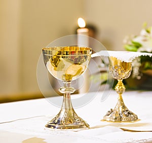 Cup with wine and ciborium with host on the altar of the holy mass