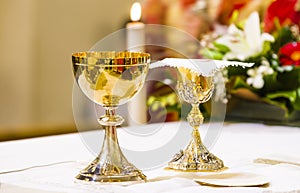 Cup with wine and ciborium with host on the altar of the holy mass