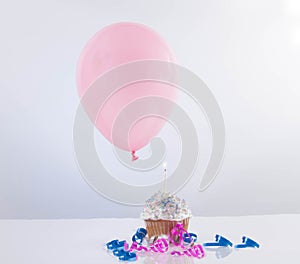 Cupcake with balloon on white background