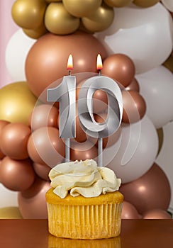 Cupcake with birthday candle on balloons background - Number 10