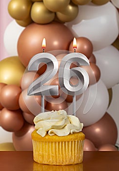 Cupcake with birthday candle on balloons background - Number 26