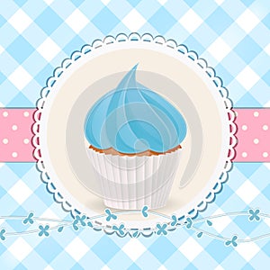 Cupcake with blue icing on blue gingham background