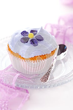 Cupcake with candied violets from flower photo