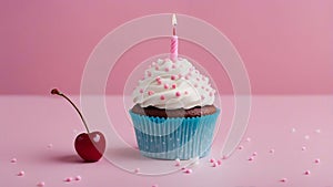 cupcake with candle A birthday cupcake with a pink candle and a cherry on top. The cupcake has white frosting