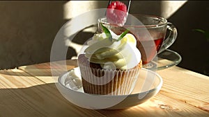 Cupcake decorated with cream and fresh raspberries