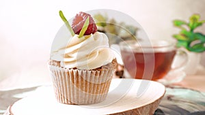 Cupcake decorated with cream and fresh raspberries