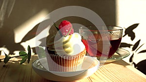 Cupcake decorated with cream and fresh raspberries